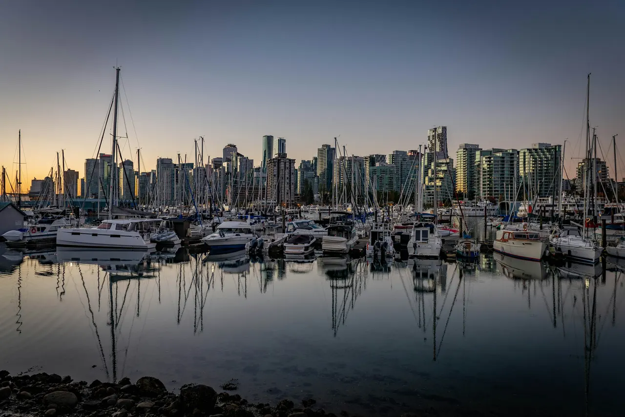 Boats in Coal Harbour at dawn with the Vancouver skyline behind