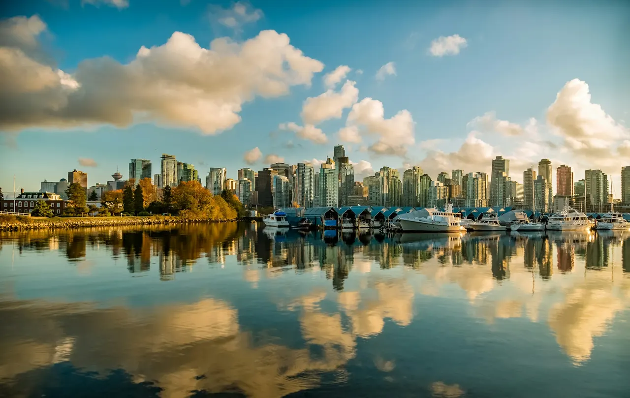 Vancouver towers reflected in calm water under clouds